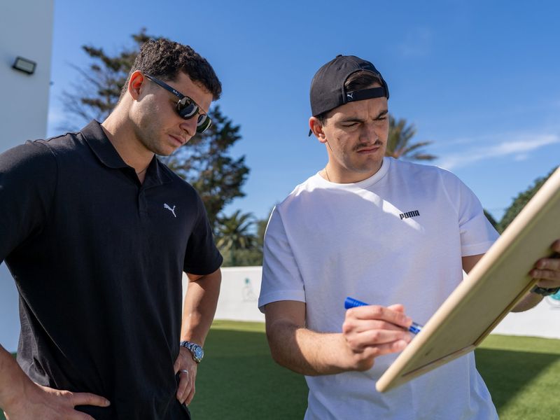A coach explains a drill on a whiteboard