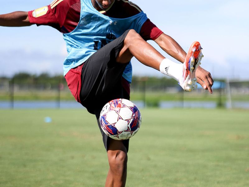 A player juggling a ball on a training pitch