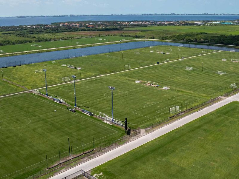Aerial view of training pitches beside the water